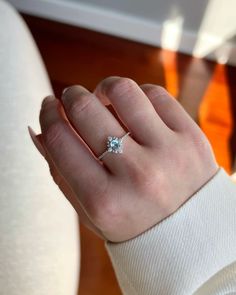 a woman's hand with a diamond ring on it