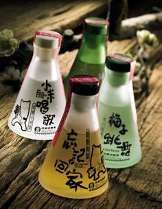 four different colored bottles sitting on top of a wooden table