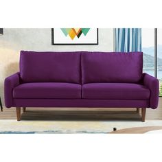 a purple couch sitting in front of a window on top of a carpeted floor