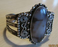 "Large sterling silver cuff bracelet with agate stone. Fred Harvey Era. Oval stone with ornate silver work. The bracelet is a wide split band with very nice stamp work. Good vintage condition with natural patina. The top is 2 7/8\" tall x 2 7/8\" wide. The inside measures 6 7/8\" including a 1 1/4\" opening. Lots of silver balls and scroll work in the design. Beautiful bracelet. Shipped by insured US first class mail. SBT-2" Handmade Oval Sterling Silver Bracelet In Vintage Style, Antique Silver Agate Jewelry, Antique Agate Silver Jewelry, Silver Agate Bangle Cuff Bracelet, Unique Silver Agate Cuff Bracelet, Vintage Silver Cabochon Cuff Bracelet, Silver Vintage Cabochon Cuff Bracelet, Silver Cabochon Cuff Bracelet In Vintage Style, Era Bracelet