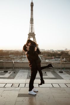 a man and woman are kissing in front of the eiffel tower, paris