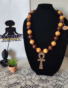 Handmade using 2 strands of 100% hemp cord, polished 25 mm pine wood beads and polished brown beads, small polished brown beads, and a 3.5 inch wood ankh pendant. Necklace is 19.5 inches long. Traditional Ankh Necklace For Gifts, Handmade Ankh Necklace For Festivals, Spiritual Brown Necklace With Wooden Beads, Handmade Ankh Symbolic Necklace, Brown Spiritual Necklaces With Wooden Beads, Adjustable Cross Necklace With Wooden Beads, Ankh Beaded Necklace, Handmade Brown Cross Jewelry, Brown Cross Necklace With Wooden Beads