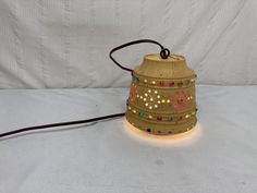 a lamp that is on top of a white cloth covered surface with beads around it