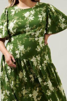 An ethereal floral print takes on a timeless silhouette with a modern taste. The Vetiver Floral print features bright, summer motifs that sit against a green-ground that decorates the Rhythm midi. A dress that features flouncy short sleeves that frame a flattering, fitted bodice that maintains a sleek fit throughout the waist, nearing the hips. A drop waist, asymmetrical skirt sits low on the hips, reminiscent of the twenties and thirties. Wear it with kitten heels and your fave bag.- Drop waist Green Printed Midi Dress For Garden Party, Garden Party Green Printed Midi Dress, Spring Green Printed Midi Dress, Green Maxi Dress With Floral Print For Garden Party, Spring Green Floral Print Maxi Dress, Green Floral Print Maxi Dress For Spring, Green Printed Floral Dress For Garden Party, Green Floral Printed Dress For Garden Party, Flowy Green Printed Floral Dress