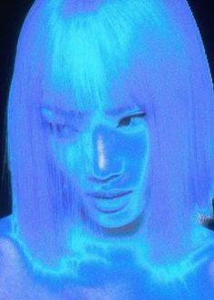 a woman's face is projected in the blue light on her head and shoulders