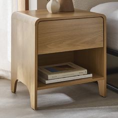 a bedside table with a book and vase on it