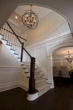 a chandelier hangs from the ceiling above a set of stairs