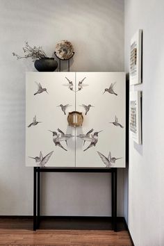 a white cabinet with birds painted on it