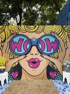 a large mural on the side of a building with woman's face wearing sunglasses