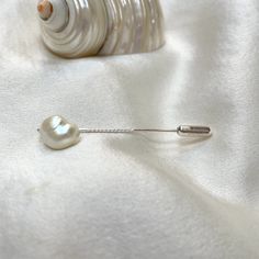 A gorgeous 11mm x 9mm baroque pearl tie pin. This naturally iridescent freshwater pearl has a soft sheen ivory lustre with hints of pink and blue gleaming, making it perfect to wear with many colours.  The 4cm long sterling silver pin has a twist half way along its lengh and  easy use push on protector which adds just a little to the overall length.  A smart addition to any man's jewel box. Tie pins are the perfect gift for men, groomsmen and best men, gentlemens' cravats, ties, and lapels. Pear Elegant Pearl Brooches For Formal Occasions, Classic White Brooches For Formal Occasion, White Pearl Brooches For Formal Occasions, Classic White Brooch For Formal Occasions, Formal White Pearl Brooches, Classic White Lapel Pin For Formal Occasions, Classic Silver Wedding Pins, Elegant Silver Pearl Brooches, Elegant White Lapel Pin For Wedding