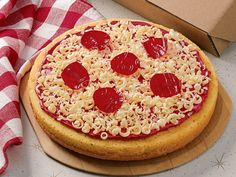 a pizza sitting on top of a wooden cutting board next to a box of pizza