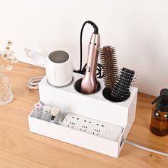 a hair dryer, combs and other items sit on a table