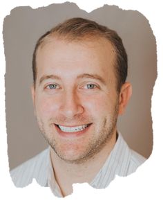 a man is smiling for the camera with a smile on his face and blue eyes