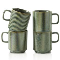 three green striped coffee mugs stacked on top of each other, with one cup in the middle