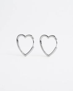 Devotional holds honoured. For all romantiques to wear love lite. Heart-shaped earrings with a seamless clicker mechanism and a high-polished finish. Available in 3 hoop sizes – small for a closer fit, medium to match any style or large for louder looks. Sold as a pair. Style & Material Style: Hoop Earrings Base material: 925 silverNickel-free: Yes Gold Coating: 14K gold plating Silver Coating: None Measurements (per piece) Small Height: 10mm Thickness: 2.4mm Weight: 1.4 grams Medium Height: 14m Hypoallergenic Heart Shaped Huggie Earrings, Hypoallergenic Heart Huggie Earrings, Silver Heart Charm Huggie Earrings, Valentine's Day Nickel-free Huggie Hoop Earrings, Silver Huggie Earrings With Heart Charm, Silver Huggie Earrings For Valentine's Day Elegant Style, Silver Huggie Earrings With Heart Charm For Anniversary, Minimalist Sterling Silver Hoop Earrings For Valentine's Day, Hypoallergenic Heart-shaped Huggie Earrings In Sterling Silver