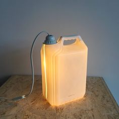 a light that is sitting on top of a wooden table next to a canister