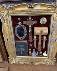 an ornate gold frame with various items in it