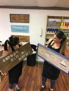 two women holding up signs in a store