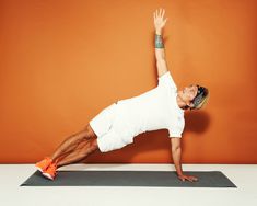 a man in white shirt and shorts doing a yoga pose with his hands on the ground