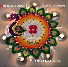 rangoli diya with peacock and candles on the floor