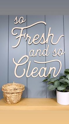 a sign that says so fresh and so clean on a shelf next to a potted plant