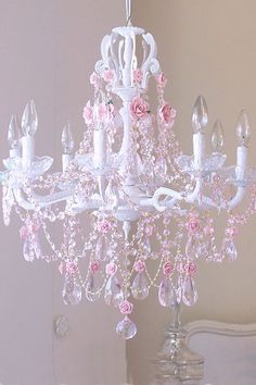 a white chandelier with pink flowers on it