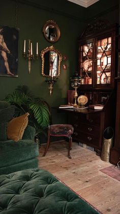 a living room filled with furniture and a painting hanging on the wall next to a green couch