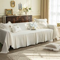 a living room with a white couch covered in pillows