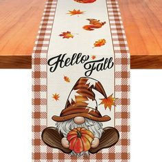 a table runner with an image of a gnome holding a pumpkin