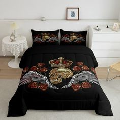 a bed with black comforter and two decorative pillows on top of it in a white room