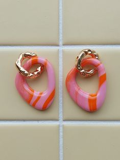 Handmade colorful statement earrings. Each pair is unique. The earrings are produced on a small scale and made with love from polymer clay. The clay is baked, polished, washed and provided with a shiny layer of epoxy. The rings are made of stainless steel. Possibly in many different colors, so are you looking for something specific? Feel free to send me a message! An original handmade gift for yourself or a friend. For more types and colors, see my Etsy page. Orange Polymer Clay Earrings, Orange Earrings Clay, Pink Artsy Polymer Clay Earrings, Artsy Pink Polymer Clay Earrings, Playful Pink Resin Earrings, Red Flower-shaped Polymer Clay Jewelry, Purple Flower-shaped Polymer Clay Earrings, Statement Earrings, Pink And Orange