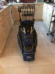 a golf bag sitting in the middle of a kitchen with utensils hanging from it's back