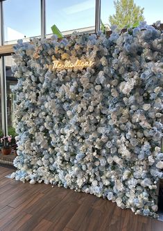 a wall covered in blue and white flowers next to a window with the word, the museum on it