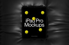 the ipad pro mockup is displayed on a black leather surface with yellow smiley faces