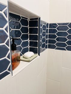 a bathroom with blue and white tiles on the wall, toiletries and soap dispenser