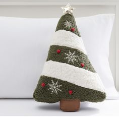 a stuffed christmas tree sitting on top of a pillow