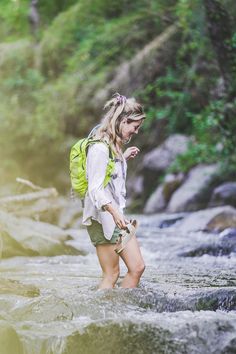 a woman standing in the middle of a river