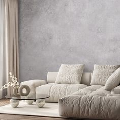 a living room with a white couch and coffee table in front of a gray wall