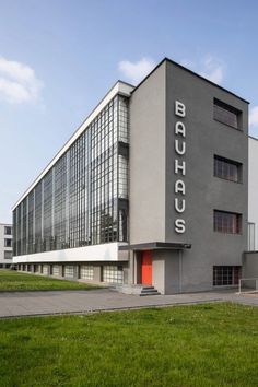 a large building with many windows on the side of it and grass in front of it