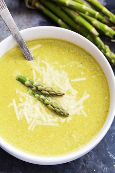 asparagus and parmesan soup in a white bowl with a silver fork