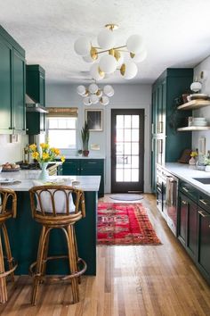 a kitchen with green cabinets and wooden floors