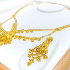 This 22k gold light patta set features a traditional festive tasseled design, perfect for adding elegance to any outfit. Weighing 55.0 grams, it showcases a yellow gold finish that enhances its intricate and celebratory appearance. The set has a length of 24 inches with a 2.5-inch drop and includes adjustable 1.5-inch links for a comfortable fit. Secured with a hook lock, it combines style and practicality. The matching earrings, each 2.2 inches long, feature screw back posts for added security. Gold Traditional Jewelry Sets For Formal Occasions, Elegant Sets With Latkans For Gifts, Elegant Gift Sets With Latkans, Elegant Jewelry Sets With Latkans For Eid, Elegant Sets With Latkans For Celebration, Elegant Celebration Sets With Latkans, Gold Jewelry Sets With Latkans For Diwali, Traditional Gold Sets For Festivals, Gold Traditional Sets For Festivals