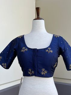 Blue Color Raw Silk Readymade Blouse with beautiful Handwork Work. Item : Readymade Blouse Size : 36 (Can be opened to Size 40) Length of the Blouse : 14 inches Length of the Sleeves : 10 inches Color : Navy Blue Blouse Fabric : Raw Silk Lining : Yes, it is fully lined Padded or Non-Padded : Padded Closure: Front Closure with hooks. Ready-to-Wear : Yes Disclaimer - :  -This is a Standard Size blouse. We do not guarantee perfect fit as every body and shape is different. Little or no alteration wo Elegant Floral Embroidered Blouse Piece For Navratri, Elegant Semi-stitched Top With Floral Embroidery, Elegant Semi-stitched Blue Tops, Blue Short Sleeve Top For Wedding, Elegant Blue Blouse With Resham Embroidery, Fitted Short Sleeve Blouse With Floral Embroidery, Navratri Long Sleeve Blouse With Floral Embroidery, Fitted Resham Embroidery Top With Short Sleeves, Blue Top With Resham Embroidery For Navratri