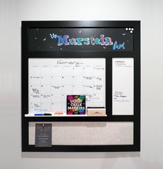 a bulletin board mounted to the wall with magnets on it and a calendar attached