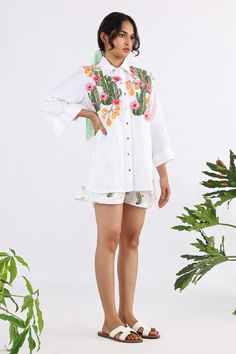 White A-line shirt with floral applique work. - Aza Fashions Summer Embroidered Long Sleeve Top For Work, Embroidered Tops For Workwear With Relaxed Fit, Relaxed Fit Embroidered Workwear Tops, Spring Floral Embroidery Relaxed Fit Shirt, Embroidered Relaxed Fit Top For Work, White Long Sleeve Blouse With Floral Applique, White Floral Embroidered Shirt For Work, Cotton Shirt With Floral Embroidery For Work, Floral Embroidered Cotton Shirt For Work