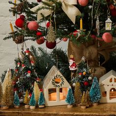 a christmas tree with ornaments on it and decorations hanging from the branches in front of it