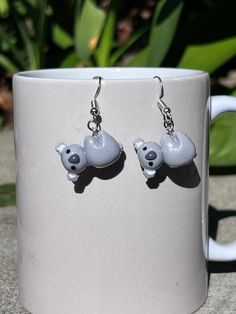 Embrace the charm of Australian wildlife with these adorable Handmade Hanging Koala Earrings! Each pair is meticulously crafted with love and attention to detail using polymer clay, making them lightweight and comfortable to wear all day long. These sweet koala earrings feature intricately sculpted koala figures hanging from earring hooks, capturing the playful essence of these beloved creatures.  Whether you're planning a trip to the zoo or adding a touch of nature to your everyday style, these koala earrings are sure to bring joy and whimsy to any outfit. They make a perfect gift for friends, family, or yourself! Each pair is handmade, so slight variations may occur, making each set truly one-of-a-kind Add a touch of Aussie charm to your jewelry collection with these delightful Hanging K Cute Resin Jewelry With Matching Earrings, Novelty Polymer Clay Dangle Jewelry, Cute Clay Drop Earrings, Fun Nickel-free Polymer Clay Earrings, Fun Polymer Clay Drop Earrings, Playful Nickel-free Resin Earrings, Fun Polymer Clay Earrings Nickel Free, Cute Adjustable Resin Earrings, Cute Hypoallergenic Polymer Clay Earrings