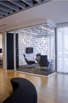 an office with a glass wall covered in words