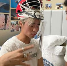 a young man wearing a helmet on top of his head while talking to another person