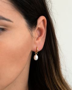 "Simple, elegant and super versatile, this dainty pair of pearl hoops is perfect to mix and match with other earrings and will easily become an everyday staple. Lightweight with an easy snap closure, and a removable pearl charm so that you can wear them with or without the pearl. * D E T A I L S * ∙ Sold as a PAIR ∙ Material: .925 Sterling Silver or 18K Gold Plated over .925 Sterling Silver ∙ Stone: Freshwater Pearl ∙ Dimensions: Inner diameter: 10mm // Pearl: Approx: 8mm (w) x 10mm (h) ∙ Hypoal Pearl Hoop Huggie Earrings, Delicate Pearl Huggie Hoop Earrings, Pearl Drop Hoop Jewelry, Classic Huggie Pearl Earrings, Teardrop Huggie Earrings With Pearl Charm, White Pearl Huggie Earrings In Dainty Style, Dainty Pearl Huggie Earrings In Small Hoop Shape, Delicate Small Hoop Pearl Earrings With Pearl Charm, Dainty Pearl Huggie Earrings Small Hoop